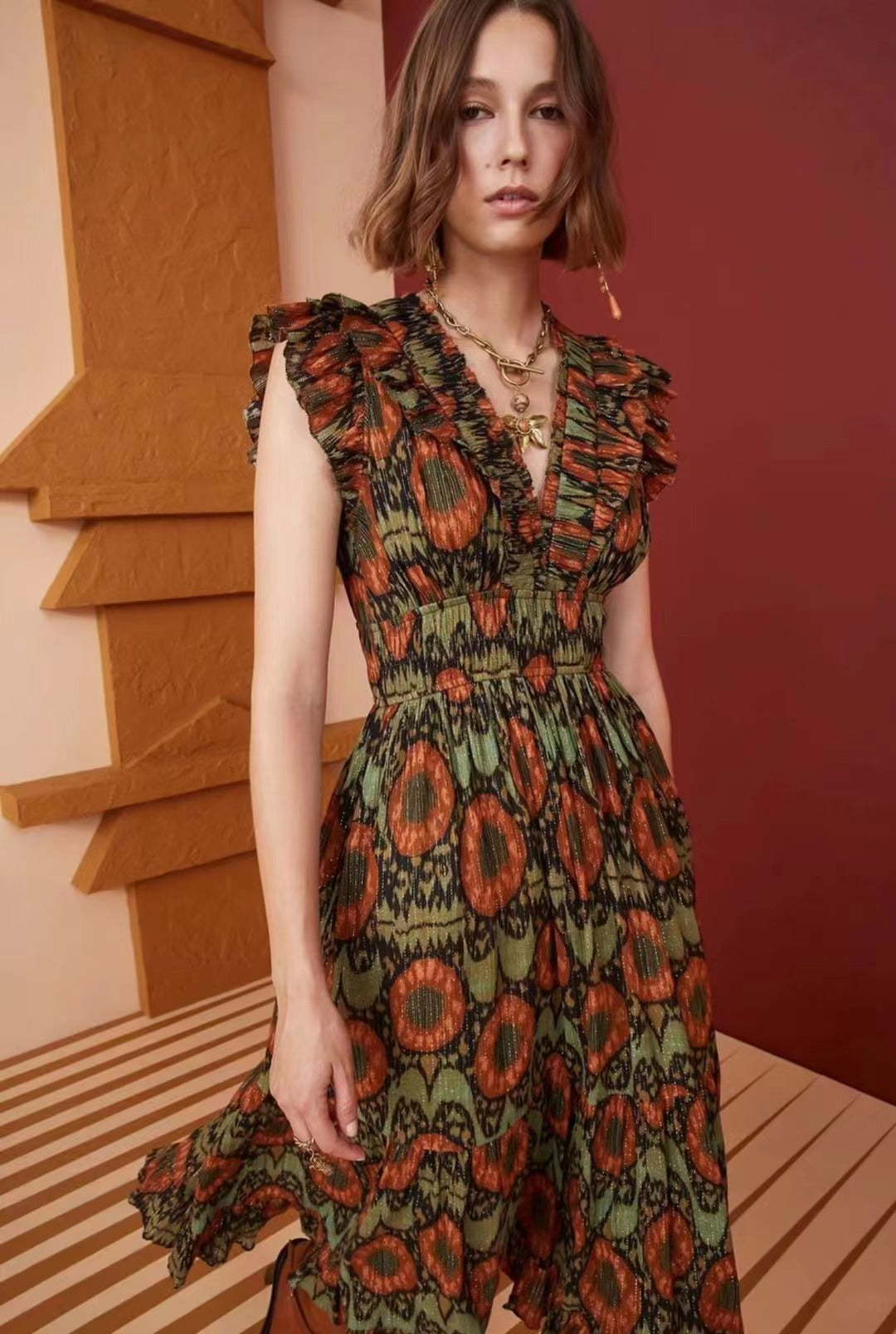 Close-up of the green and orange patterned metallic jacquard fabric on the dress.