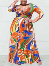 Woman wearing a vibrant orange and blue abstract floral print maxi dress with 3/4 sleeves and a V-neckline.