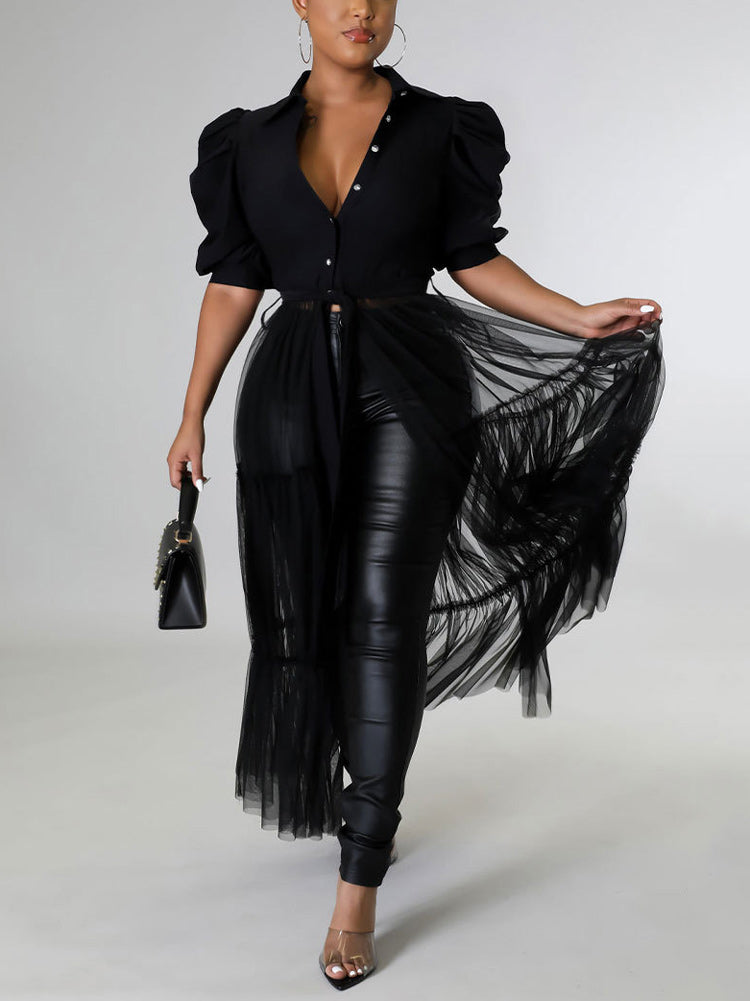 Woman wearing a black maxi dress with puffed sleeves and a tiered tulle skirt over black pants