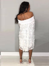Back view of a woman in a white off-the-shoulder polka dot dress