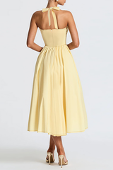 Back view of a pale yellow halter midi dress with a fitted bodice and full skirt.