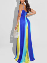 Back view of a woman wearing a blue, yellow, and white tie-dye maxi dress, showcasing the flowing silhouette.