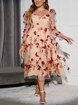 Detail of the red butterfly appliques and floral embroidery on the sheer mesh sleeves and bodice of a plus-size A-line dress.