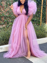model in a pink tulle evening gown with a deep V-neck and voluminous ruffled sleeves