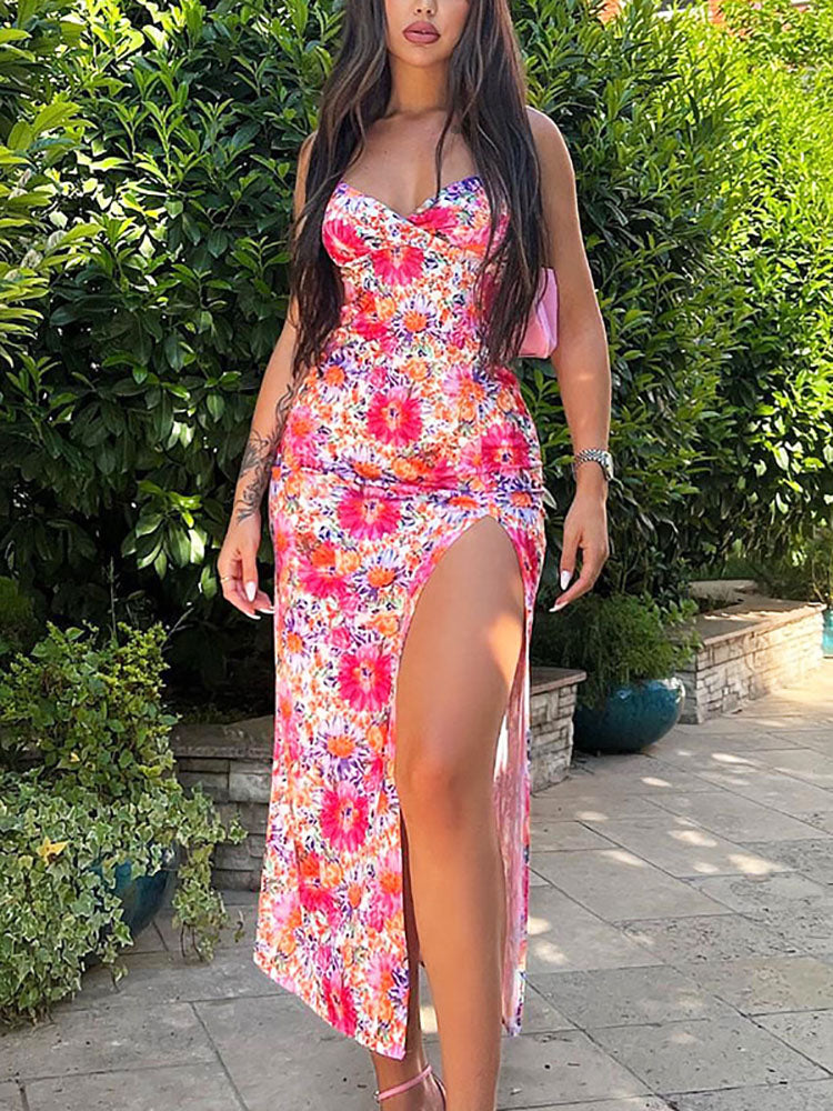 Side view of a woman in a floral print midi dress with a high slit and cami straps.