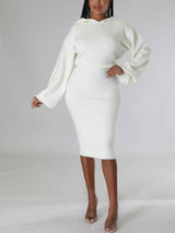 Woman wearing a white hooded knit sweater and pencil skirt set, front view.