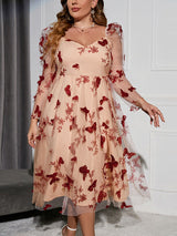 Close-up of a plus-size woman's torso in a sheer mesh dress adorned with intricate red butterfly appliques and floral embroidery.
