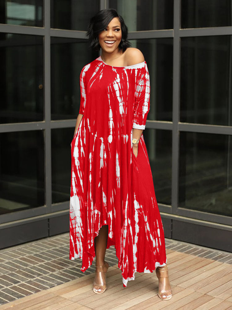 Woman wearing a red tie-dye maxi dress with an asymmetrical hem and three-quarter sleeves, standing outdoors.