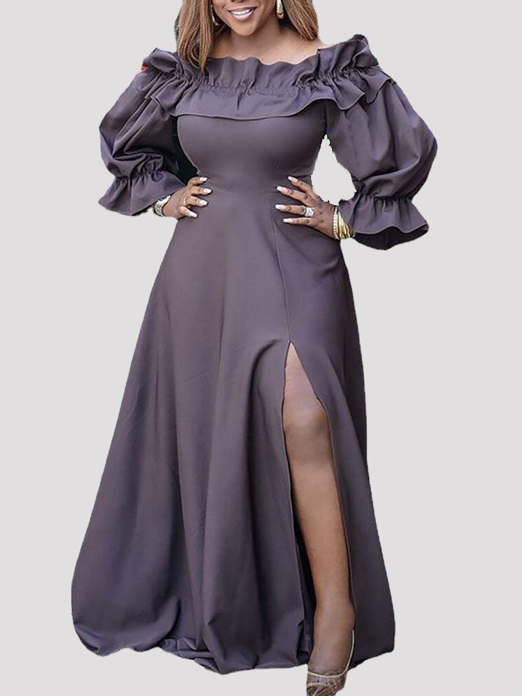 Close-up of the upper body of a woman in a dark grey off-the-shoulder maxi dress with ruffle details.