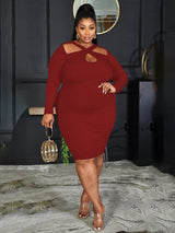 Woman wearing a burgundy long-sleeved ribbed knit bodycon dress with a cutout neckline and a gold clutch bag.