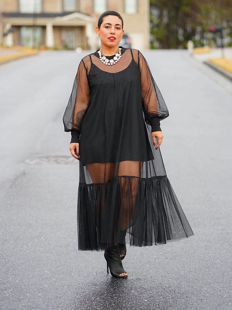 Full-length view of a woman in a black sheer dress.