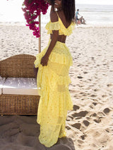 Back view of a woman in a yellow polka dot maxi dress on the beach
