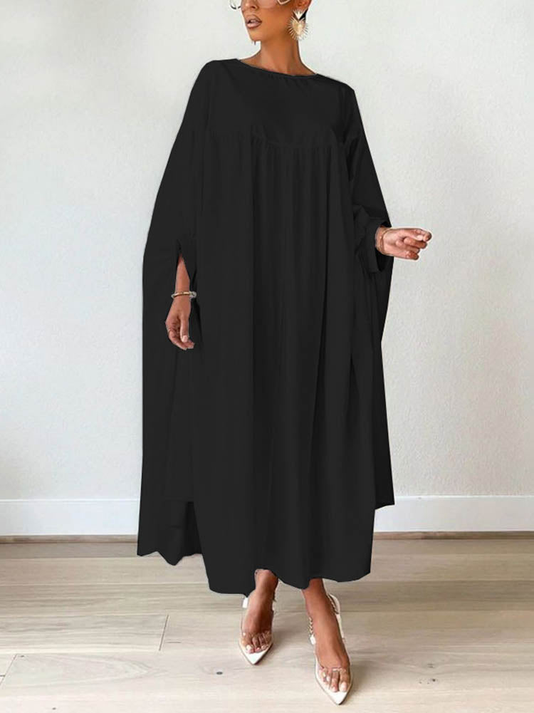 Woman wearing a black maxi dress with flowy sleeves and clear pointed-toe heels