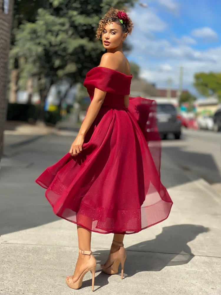 Back view of a woman in a red off-the-shoulder dress with a flared skirt, showcasing the back detail.