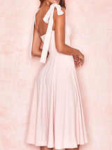 Back view of a woman in a pink midi dress showcasing the zipper and tie shoulder straps.