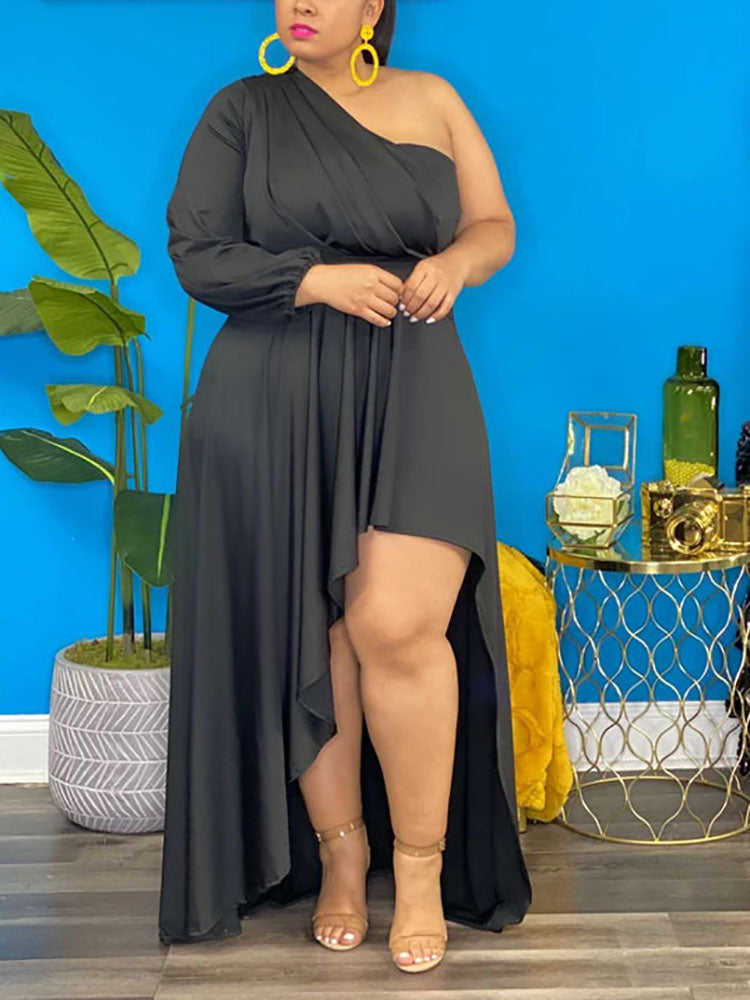 Woman wearing a black one-shoulder high-low maxi dress with ruched detailing and a long sleeve on one side.