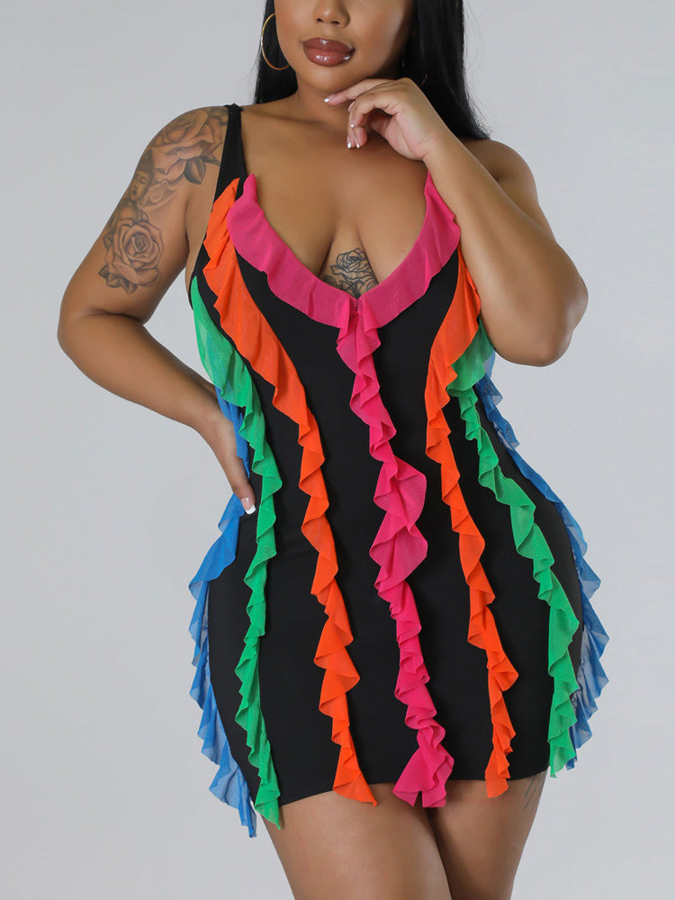 Close-up portrait of a woman wearing a black sleeveless mini dress with colorful ruffled detailing around the neckline and chest area.