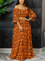 Woman wearing an orange off-the-shoulder maxi dress with a geometric print and a gold belt.