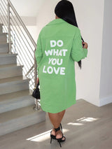 Back view of a woman wearing a lime green long-sleeve button-down shirt dress with 'DO WHAT YOU LOVE' graphic print.