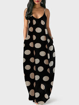 Woman wearing a black polka dot maxi dress with spaghetti straps and pockets, front view