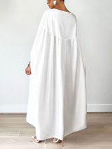 Back view of a woman wearing a white maxi dress with flowy sleeves