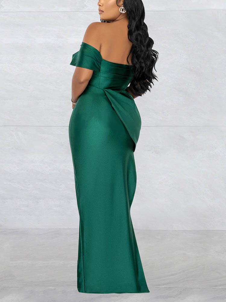 Back view of a woman in a floor-length emerald green off-the-shoulder dress with draped detailing
