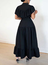 Rear view of a woman in a black ruffled midi dress, showing the tiered hem.