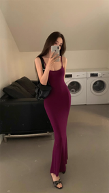 Woman in a plum maxi dress with spaghetti straps taking a mirror selfie.