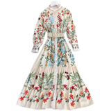 Cream floral print maxi dress with long sleeves and a belted waist, displayed on a white background.
