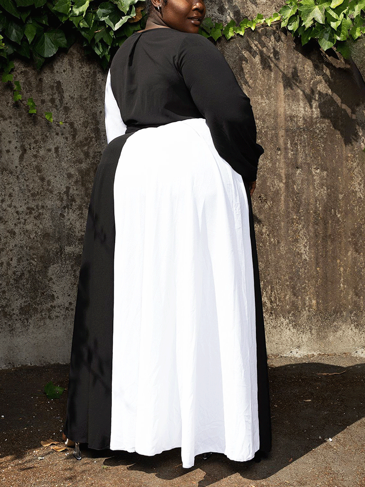 Back view of a woman in a black and white color-block maxi dress.