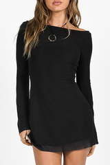 Woman wearing a black long sleeve mini dress with a boat neck and sheer hem.