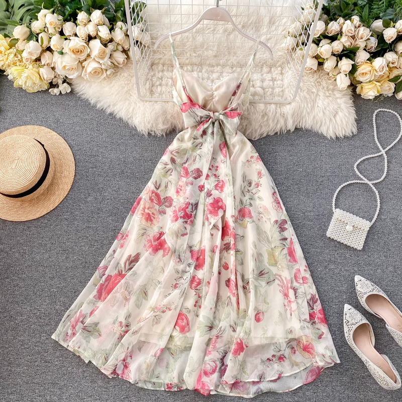 A flat lay of a floral print midi dress with a straw hat, a beaded clutch, and sparkly heels.