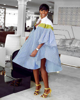 Close-up on the design details of a striped shirt dress with exaggerated sleeves and a collared neckline.
