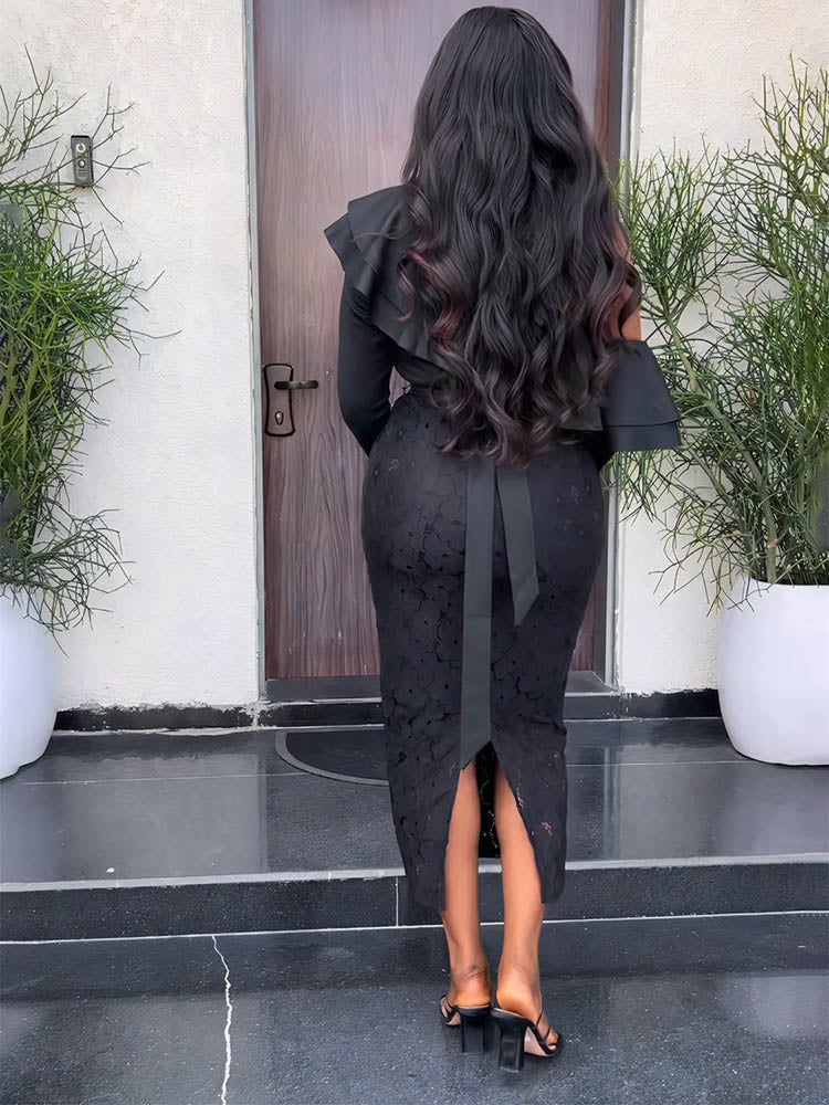 Back view of a woman wearing a black one-shoulder dress with ruffle detail and lace skirt.