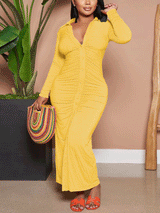 Woman wearing a yellow ruched button-down maxi dress and colorful handbag