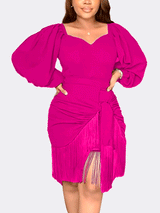 Woman wearing a vibrant pink long puff sleeve dress with a sweetheart neckline, ruched detailing, tie detail, and fringe hem.