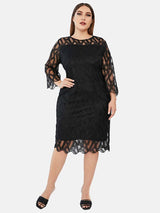 Plus-size model wearing a black lace sheath dress with bell sleeves and a round neckline.