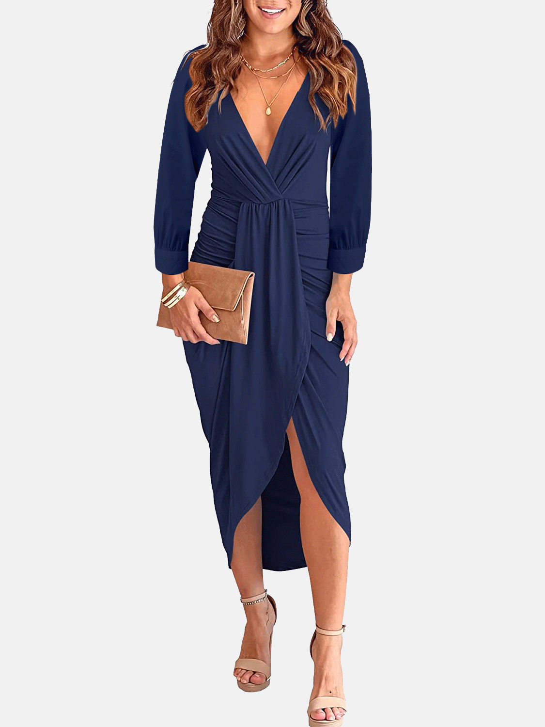 Woman wearing a navy blue long-sleeve V-neck ruched waist dress with an asymmetrical hem and a clutch bag.
