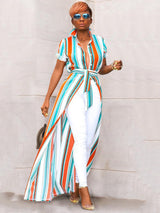 Full body shot of a woman in a striped maxi shirt dress and white skinny jeans