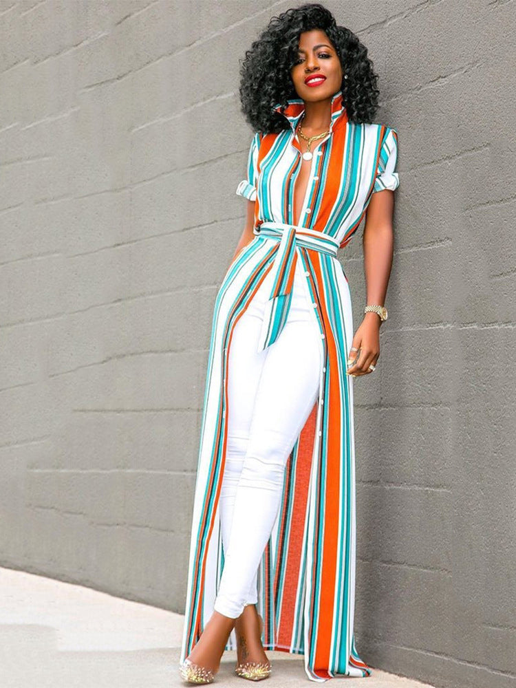 Woman leaning against a wall wearing a colorful striped maxi shirt dress