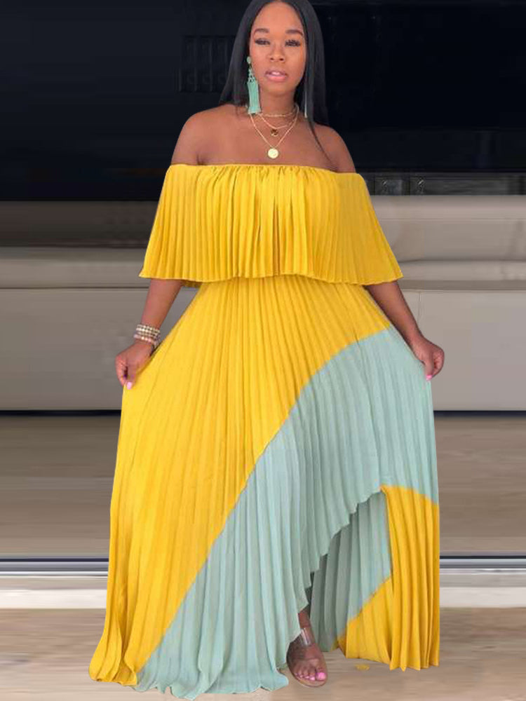 Woman wearing a yellow and mint green off-the-shoulder pleated maxi dress with an asymmetrical hem.