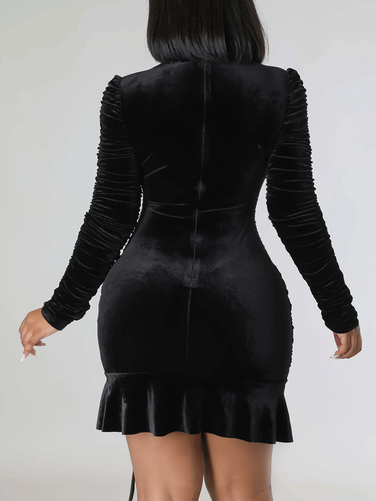 Back view of a woman in a black velvet ruched dress.