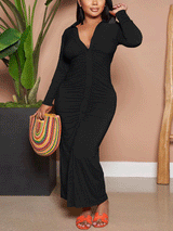 Woman wearing a black ruched button-down maxi dress and colorful handbag