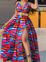 Woman wearing a vibrant striped print maxi dress with a gold belt and a high slit.