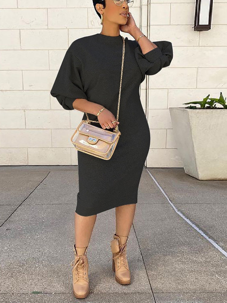 Woman wearing a charcoal knit midi dress with puff sleeves and tan lace-up boots.