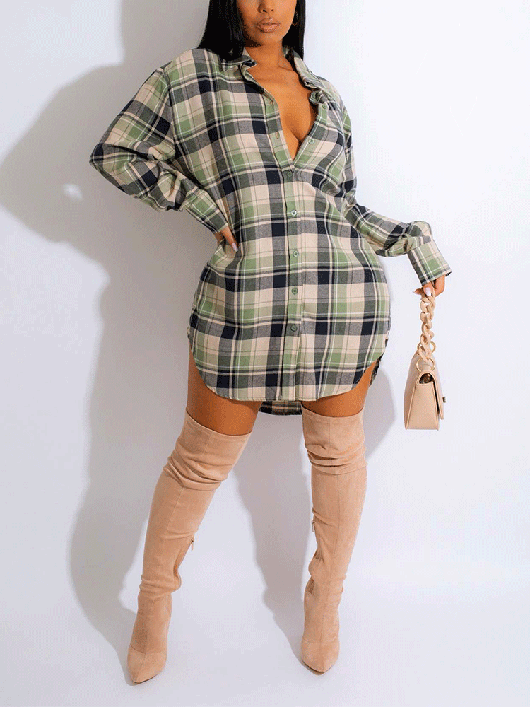 Woman wearing a green and black plaid shirt dress with thigh-high beige boots and a light beige handbag, front view.