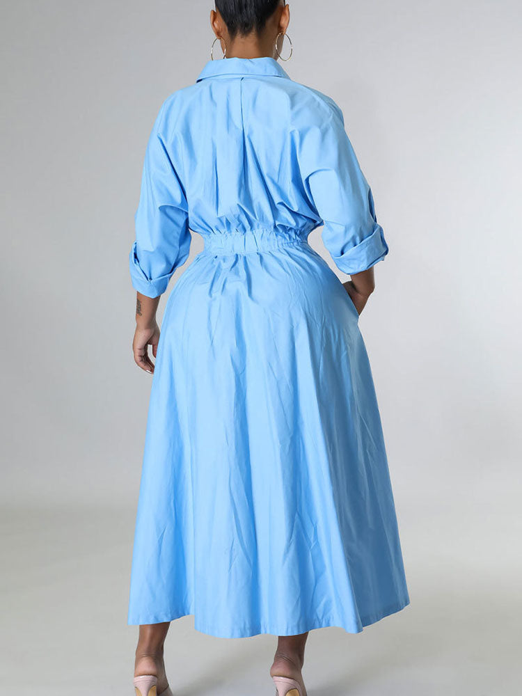 Rear view of a woman wearing a light blue button-down shirt dress.