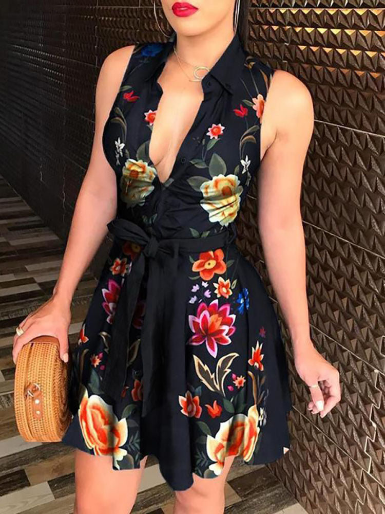 Woman wearing a sleeveless V-neck mini dress with a floral print and tie waist.