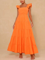 Woman wearing an orange tiered maxi dress with flutter sleeves and a square neckline, front view.
