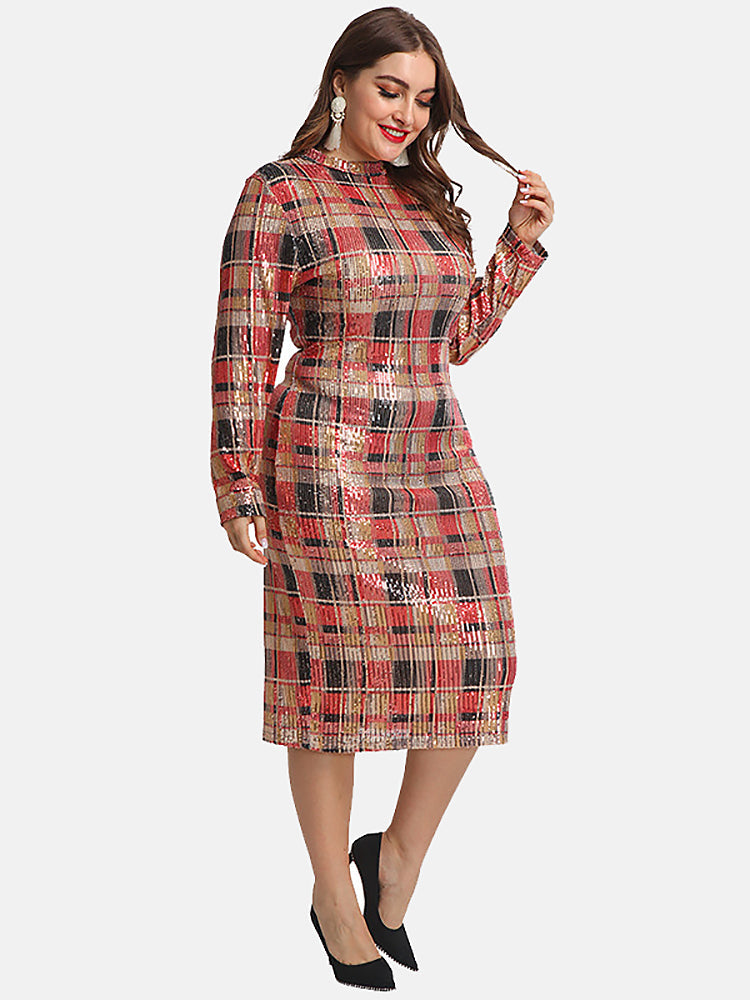 Woman adjusting her hair while wearing a sequined plaid pencil dress with long sleeves and a mock neck.